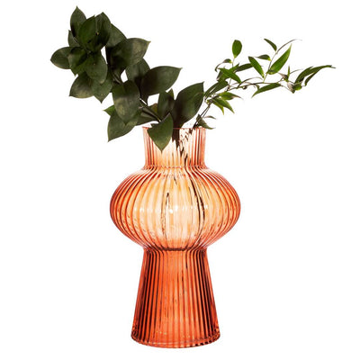 Dark peach tall fluted glass vase with vibrant leaves, enhancing home décor
