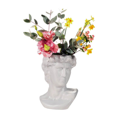 Lush flowers nestled in a classic grey Greek head planter, adding natural beauty to any setting