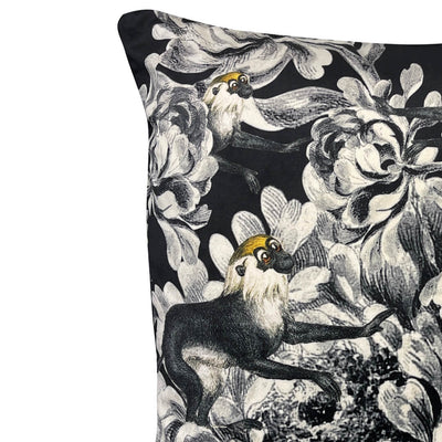 Close up view of decorative black floral and monkeys velvet cushion