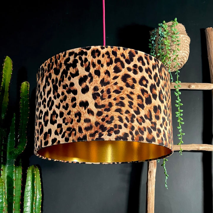 A leopard print lampshade features a warm and inviting gold lining, emitting a cosy glow that creates a relaxing ambience.