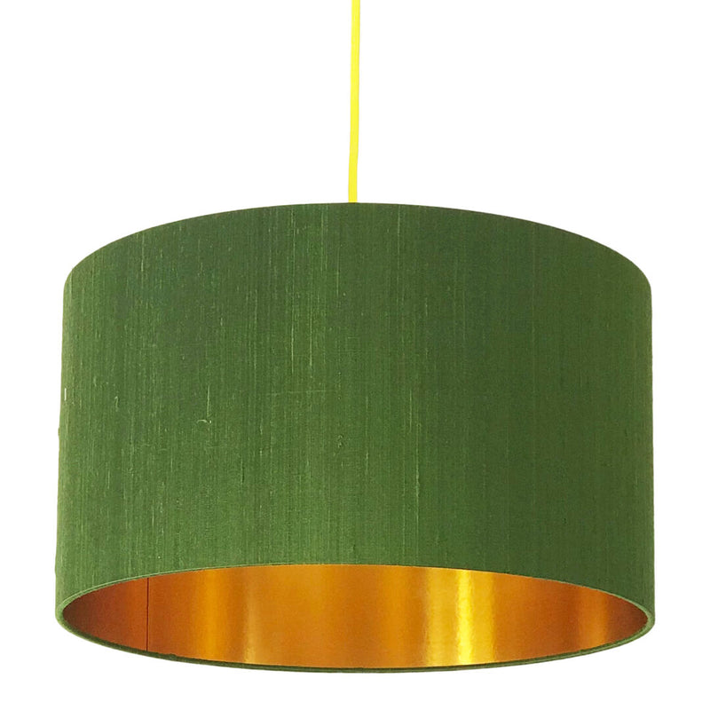 An elegant moss green silk lampshade featuring a luxurious gold lining, creating a warm, sophisticated glow when illuminated