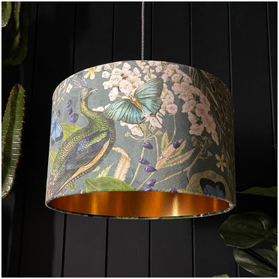 Peacock velvet lampshade with fluttering butterflies and blooming florals, perfect for creating a warm and inviting ambiance.